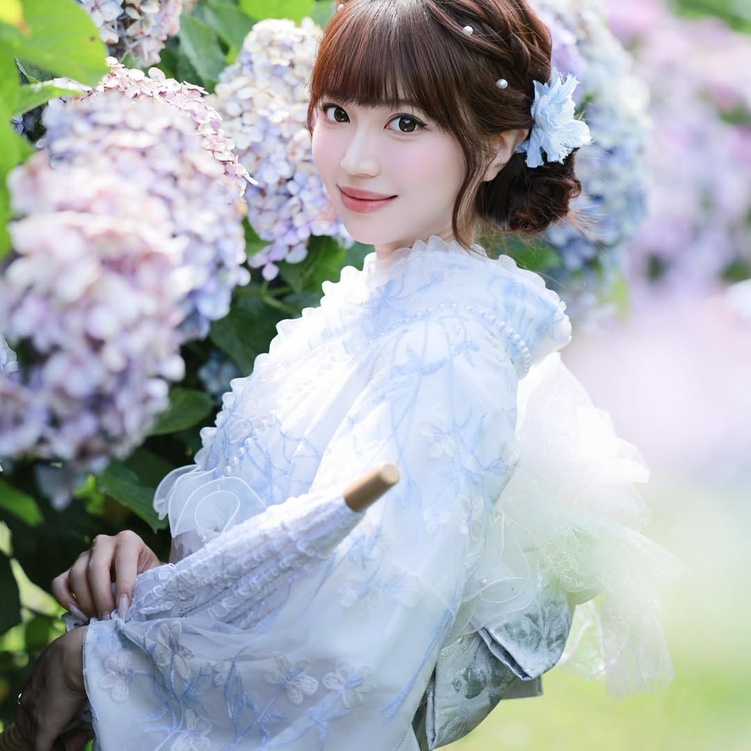 初夏の紫陽花を背景に浴衣姿で記念撮影を楽しむ女性