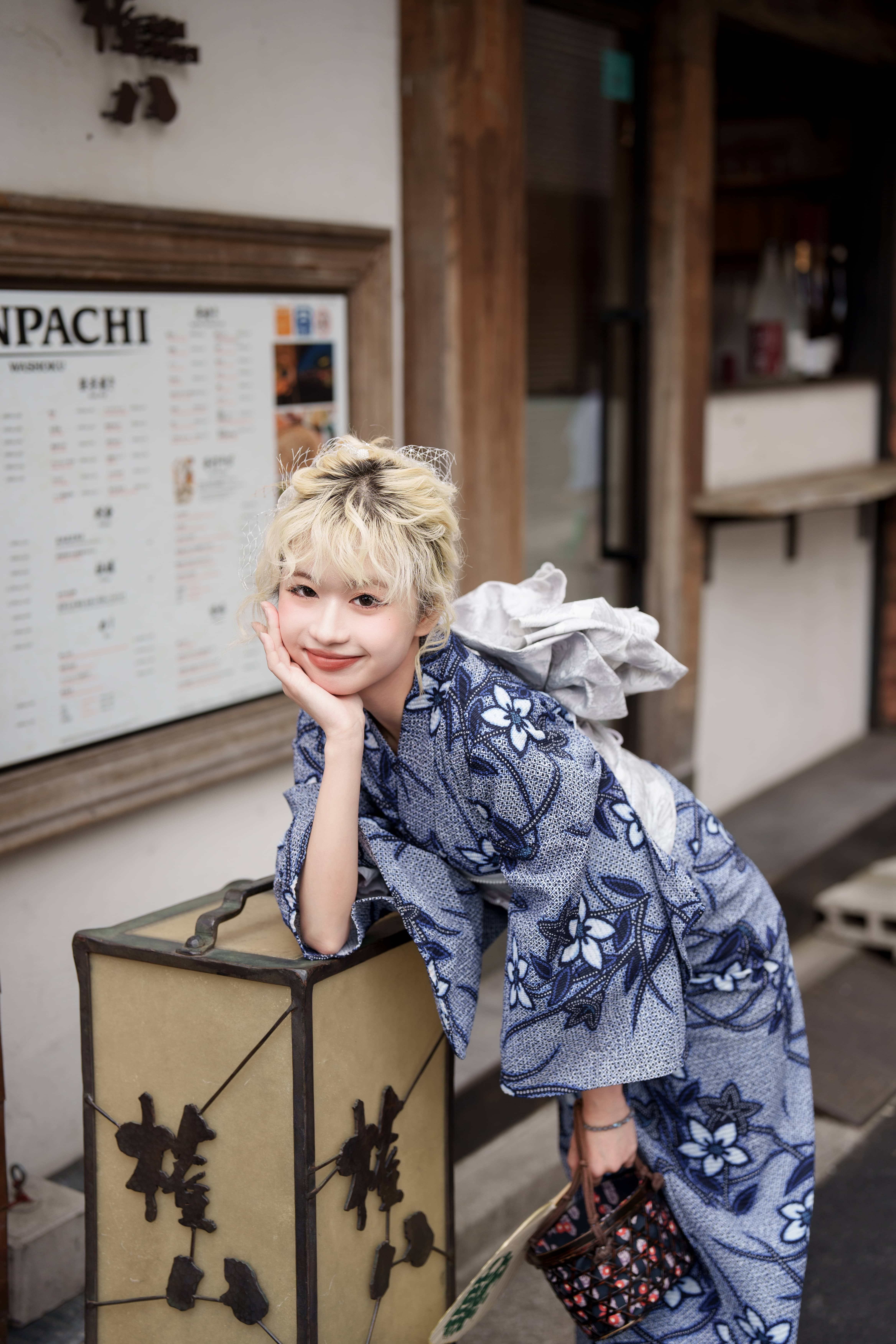 初秋にも映える青い浴衣姿の女性が、浅草の和風店舗前でおしゃれに撮影を楽しむ様子